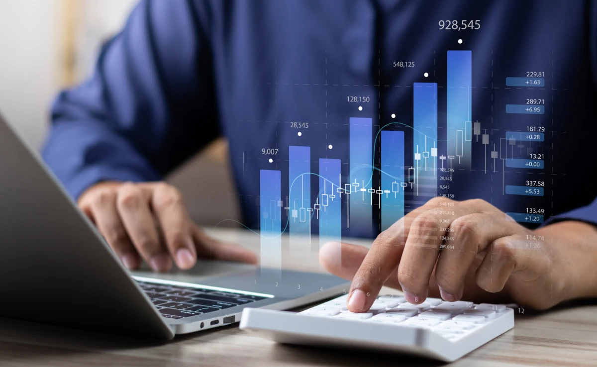 Hands typing with financial graph overlay